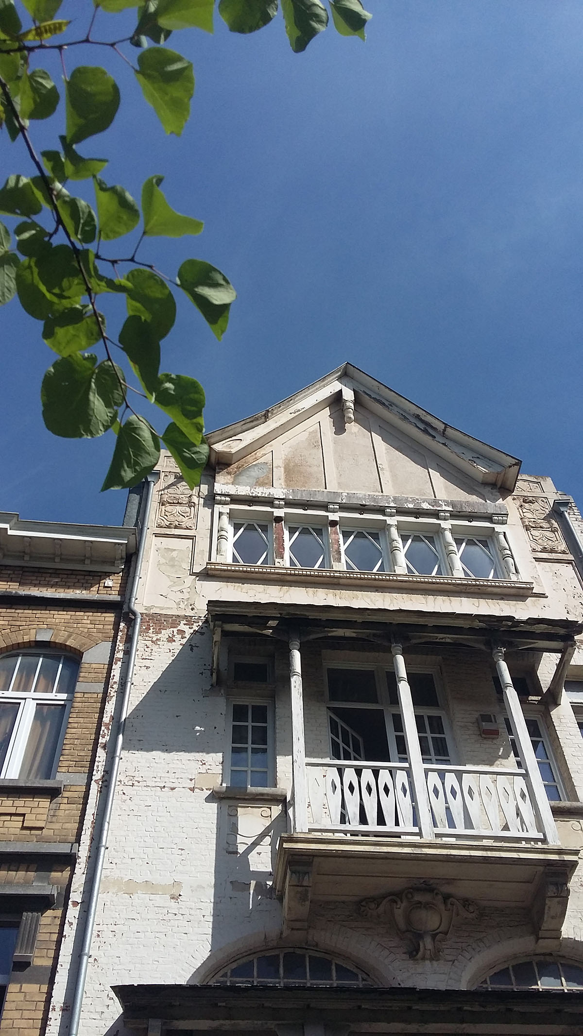 photo partielle de la façade principale de la Villa avant travaux : elle est entièrement sous peinture blanche abimée