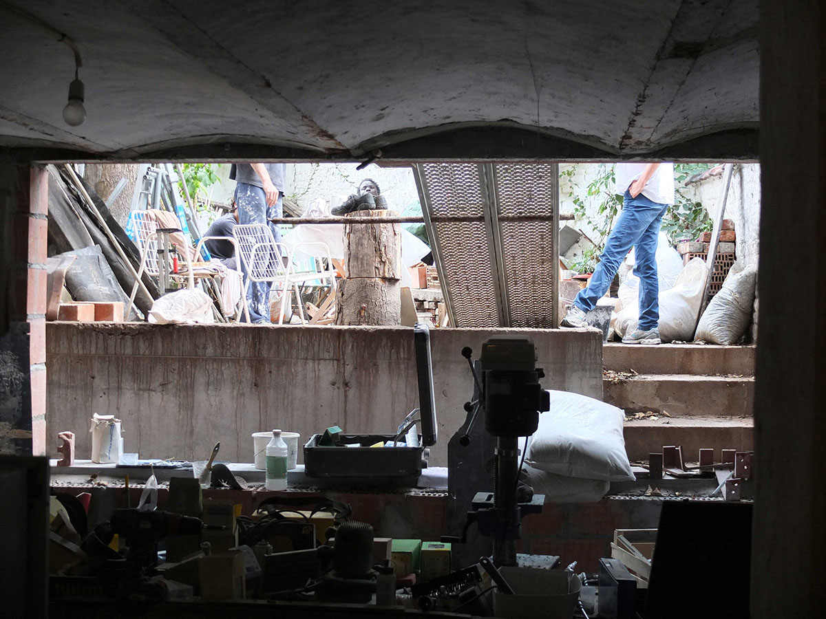 photo en cours de chantier, vue depuis l'atelier semi enterré vers la cours anglais et le jardin. On devine l'équipe en train de discuter des travaux